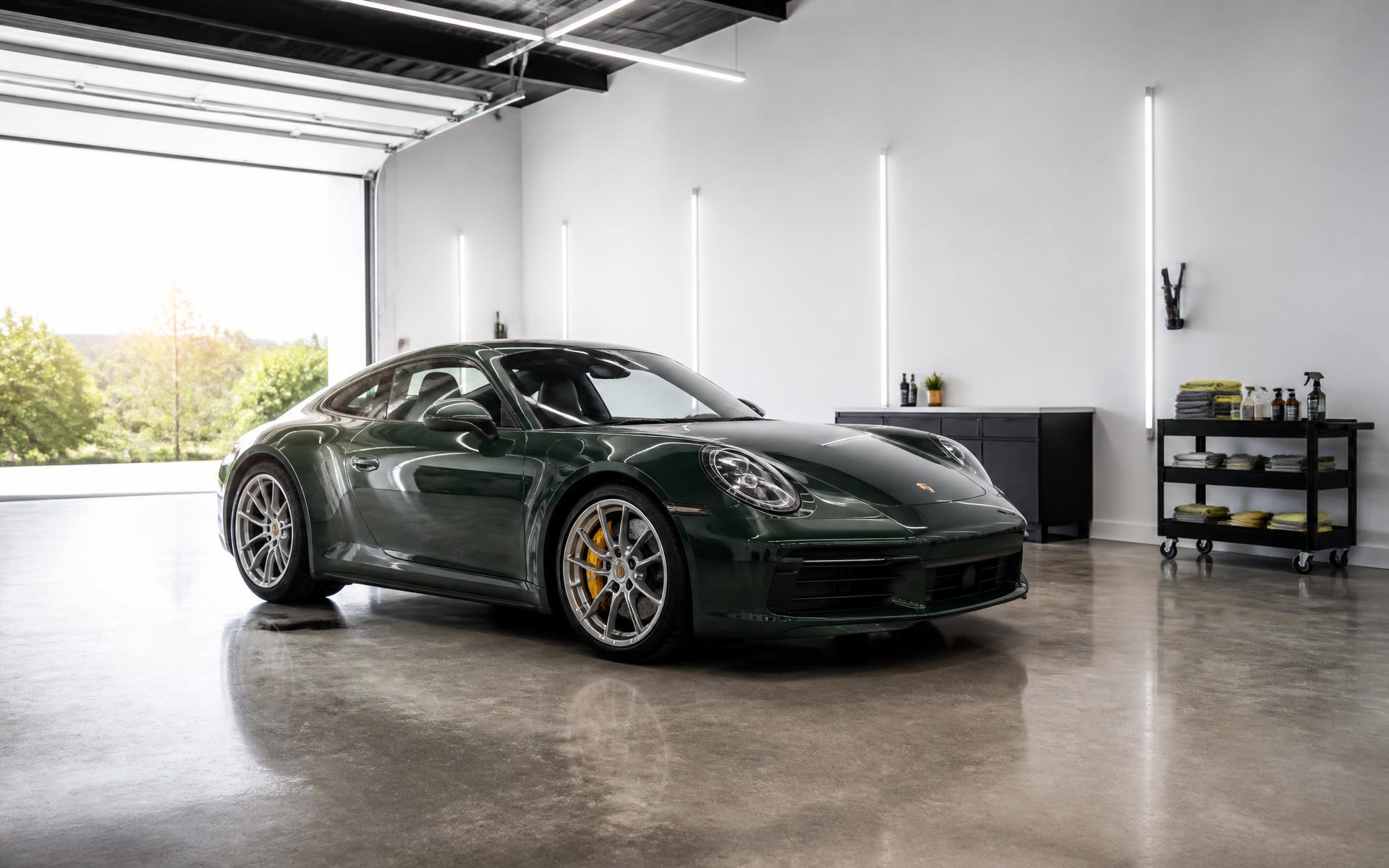 Clean sports car parked in a bright detailing bay with polished concrete floor and open garage door